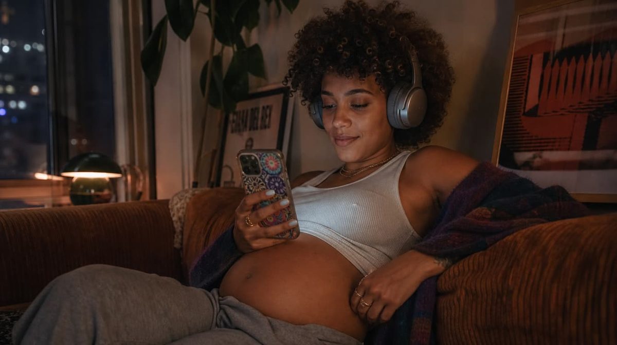 A pregnant woman using a hypnobirthing app on her phone